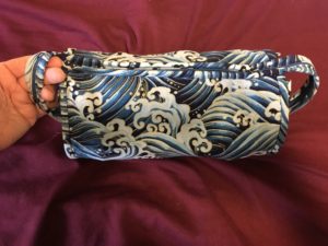 A zippered roll sewing kit made with fabric of blue waves
