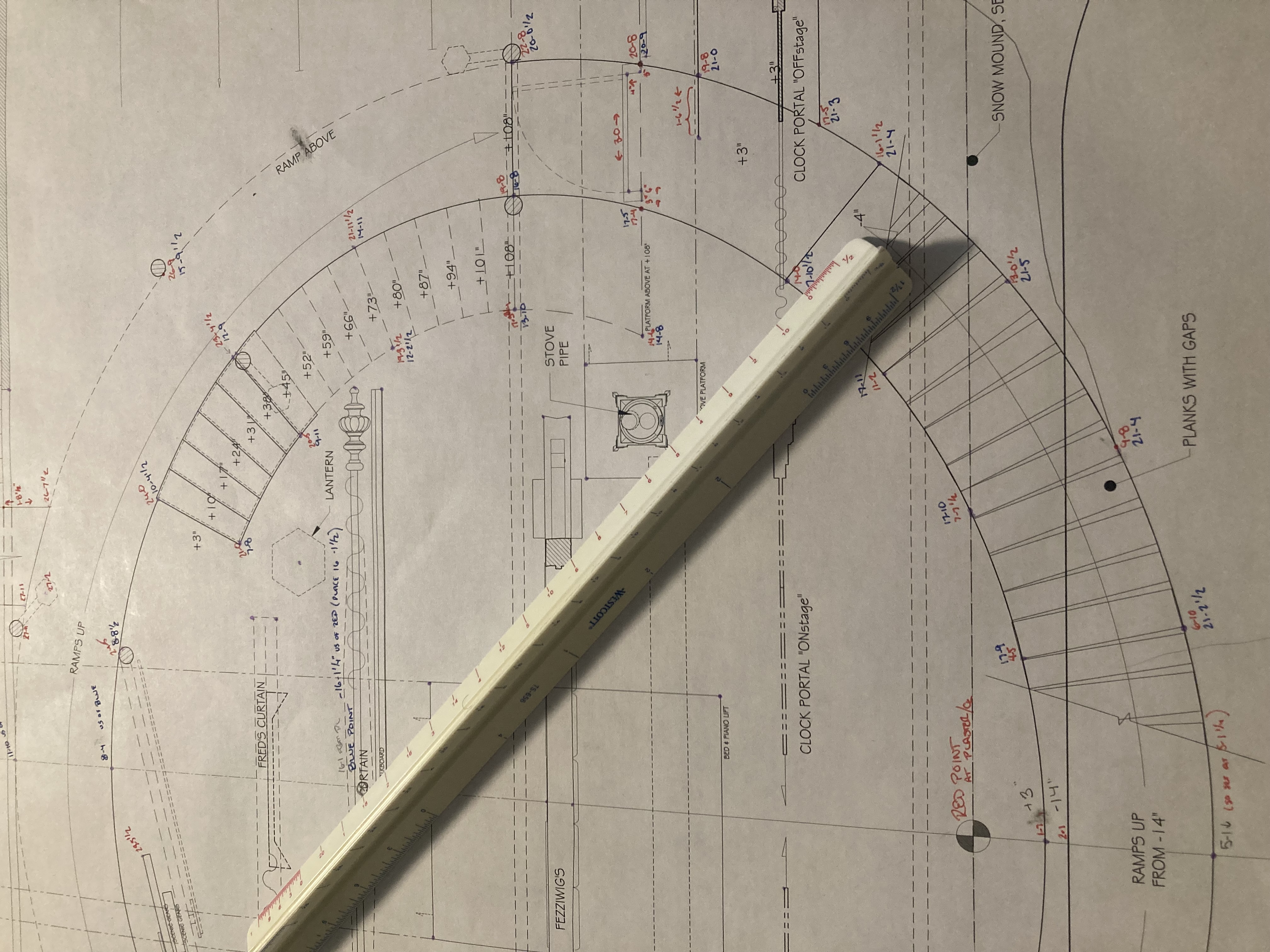 An architect's scale rule sits on a theatrical ground plan. There are two points marked red point and blue point, and then many other points have numbers written in those two colors.