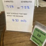 Two laminated tabletop tent signs are shown giving alternate times that breaks can be taken as well as a sign saying less than 10 minutes 'til break