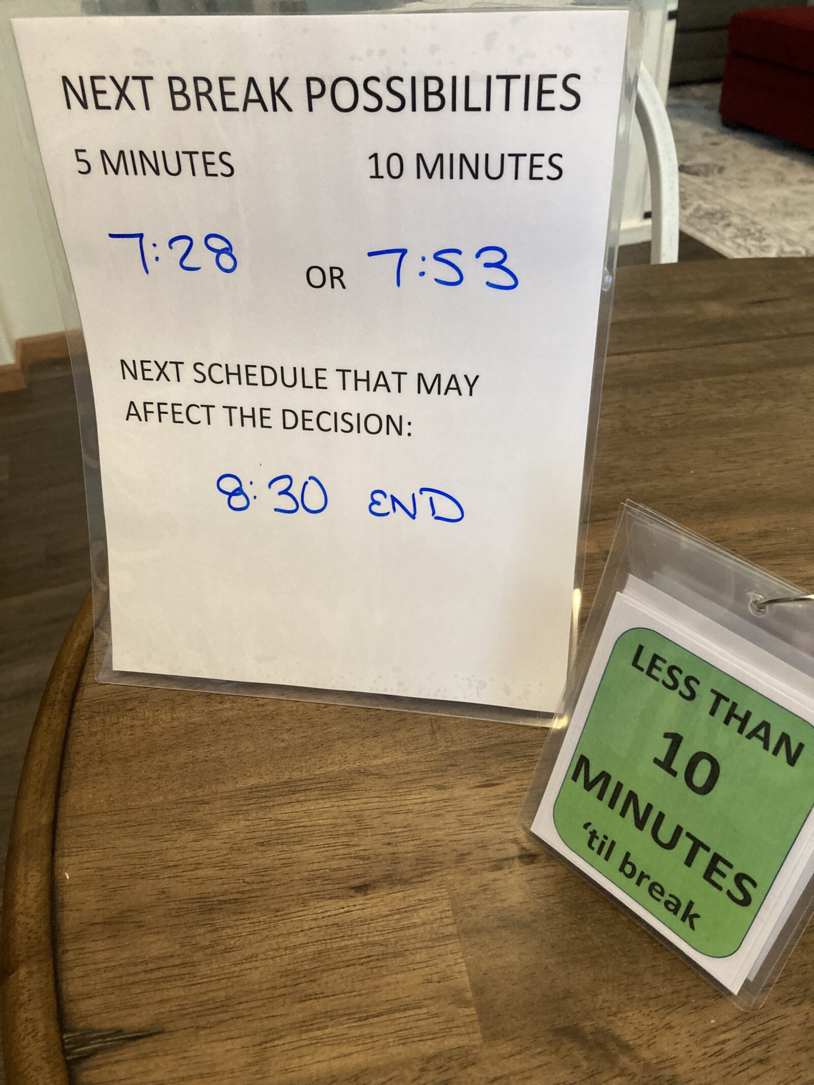 Two laminated tabletop tent signs are shown giving alternate times that breaks can be taken as well as a sign saying less than 10 minutes 'til break