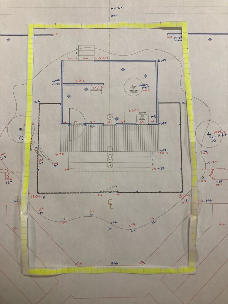 A theatrical groundplan is shown with a yellow rectangle of paper laid on top of it vertically to represent the rehearsal hall dimensions available.