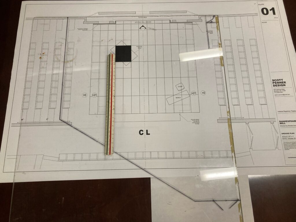 A theatrical groundplan is shown with a transparent overlay of the rehearsal hall dimensions. There is also an architect's scale rule pictured.