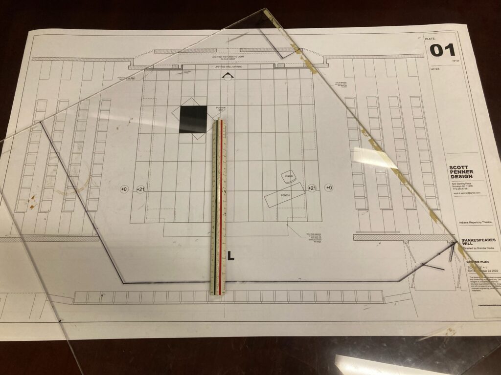 A theatrical groundplan is shown with a transparent overlay of the rehearsal hall dimensions. There is also an architect's scale rule pictured.